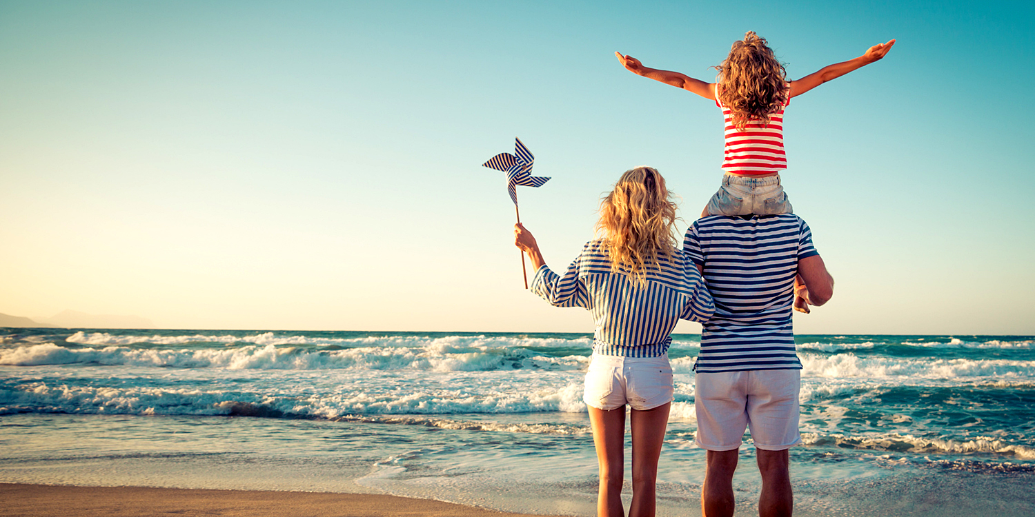 Happy family on the beach. People having fun on summer vacation. Father, mother and child against blue sea and sky background. Holiday travel concept